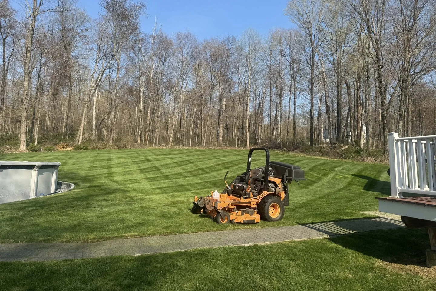 A front yard with fresh mulch beds, a fieldstone wall and a newly cut lawn